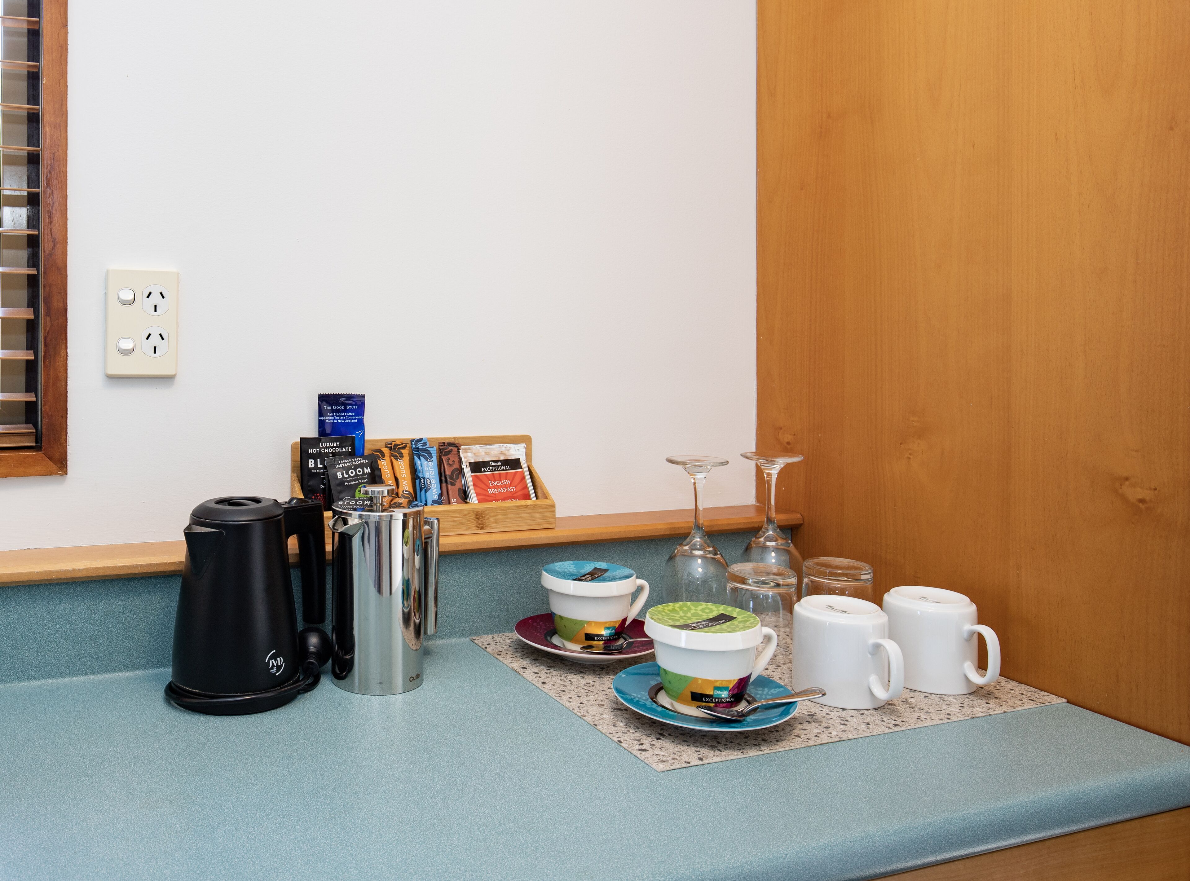 Una kitchenette equipada con cafetera, hervidor de agua y una bandeja con bolsitas de té.