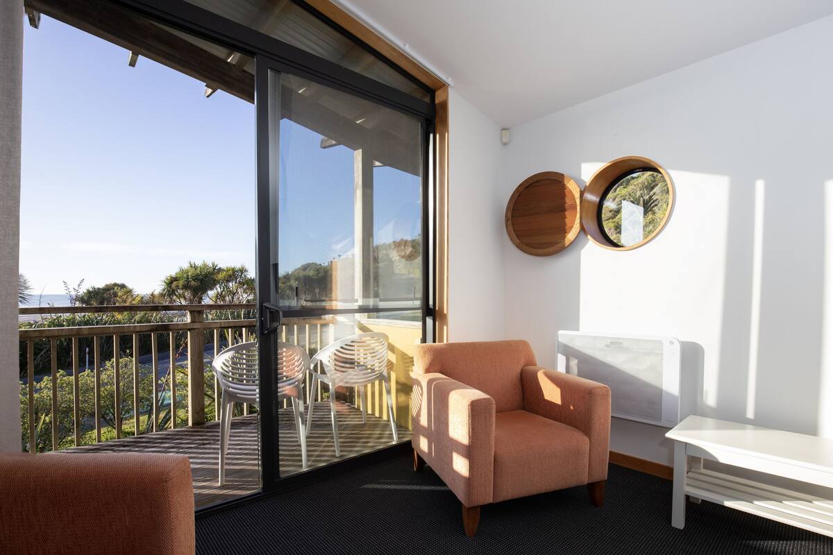 Ein Balkon mit Stuhl, Tisch und Blick ins Freie.