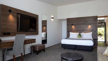 A modern bedroom with a large bed, a desk, and a chair.