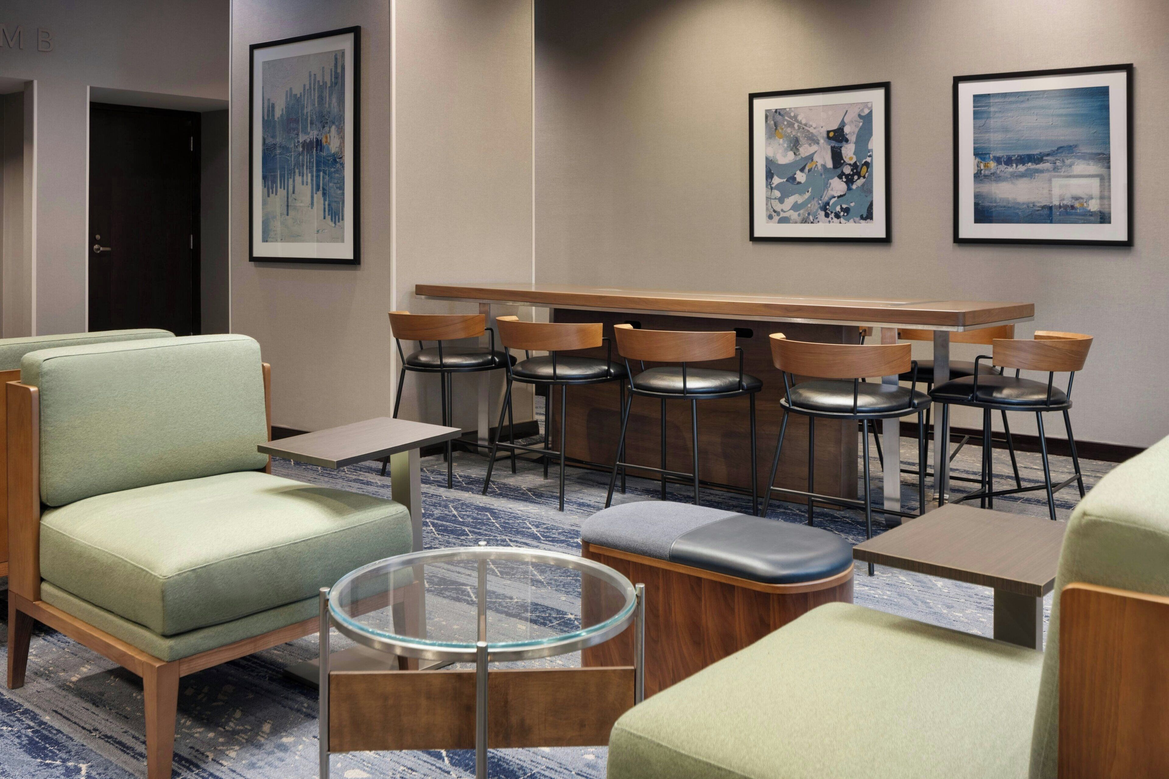 Un hall de hotel con zonas de estar, un bar y obras de arte en las paredes.