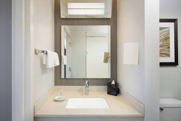 A modern bathroom with a large mirror, a white sink, and a towel rack. - Courtyard by Marriott Chicago Magnificent Mile (Chicago)