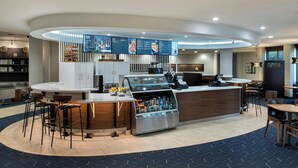 A modern hotel lobby with a curved reception desk, bar area, and seating. - Courtyard by Marriott Ewing Princeton (Trenton)