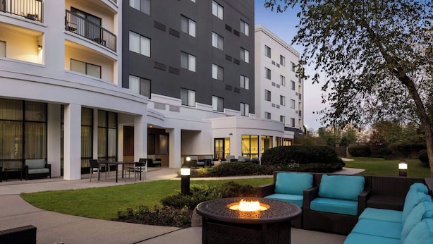 A hotel courtyard with outdoor seating, a fire pit, and a well-maintained lawn. - Courtyard by Marriott Ewing Princeton (Trenton)