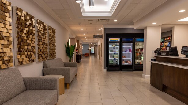 Un vestíbulo de hotel con mostrador de recepción, zona de estar y minibar.