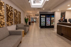 A hotel lobby with a reception desk, seating area, and a minibar. - Hampton Inn Lawrenceville Duluth (Lawrenceville)
