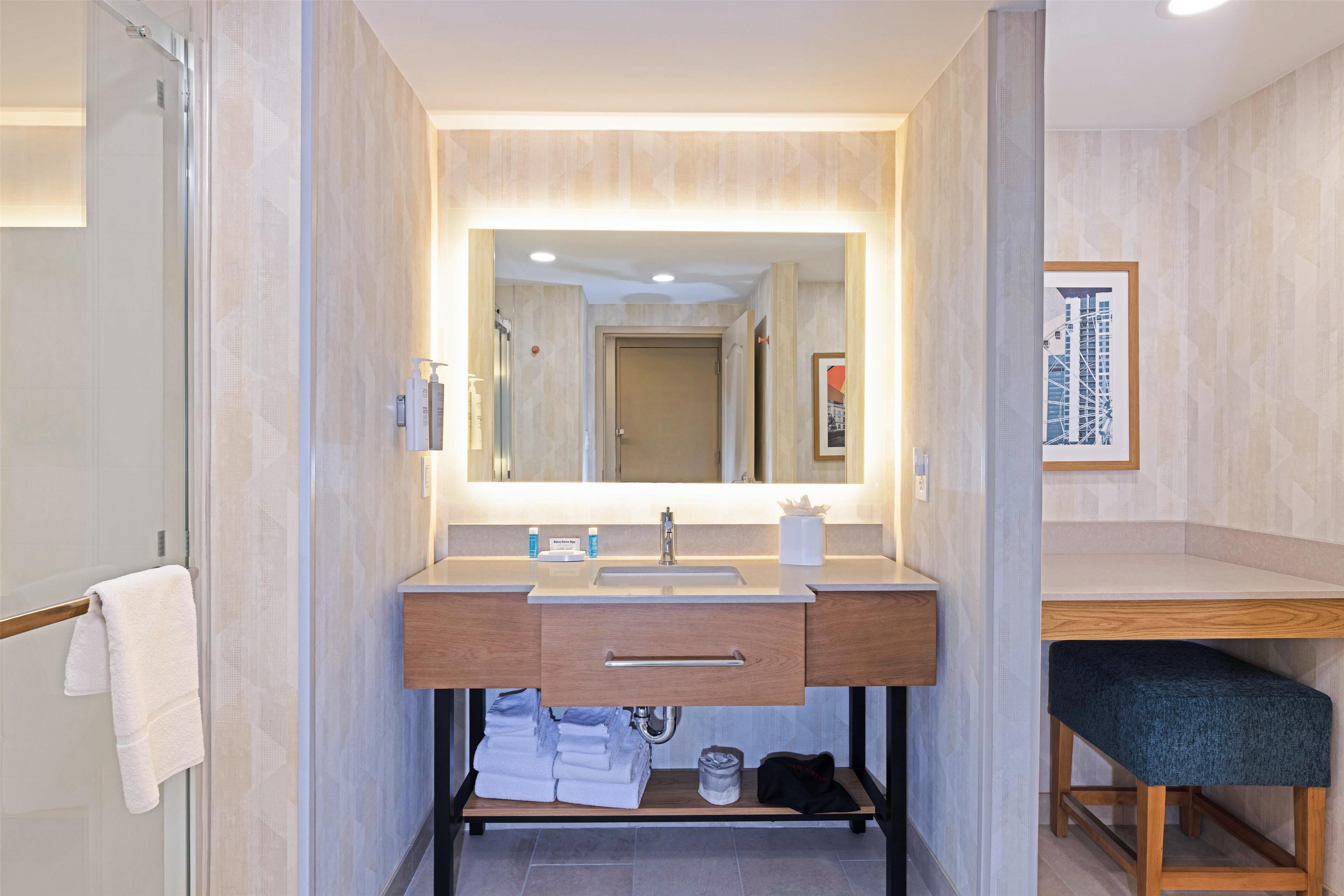 A modern bathroom with a large mirror, a sink, and a vanity.