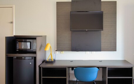 A compact kitchenette with a microwave, refrigerator, and a small sink.