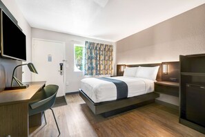 A modern hotel room with a bed, desk, chair, and a television. - Motel 6 Issaquah, WA - Seattle - East (Issaquah)