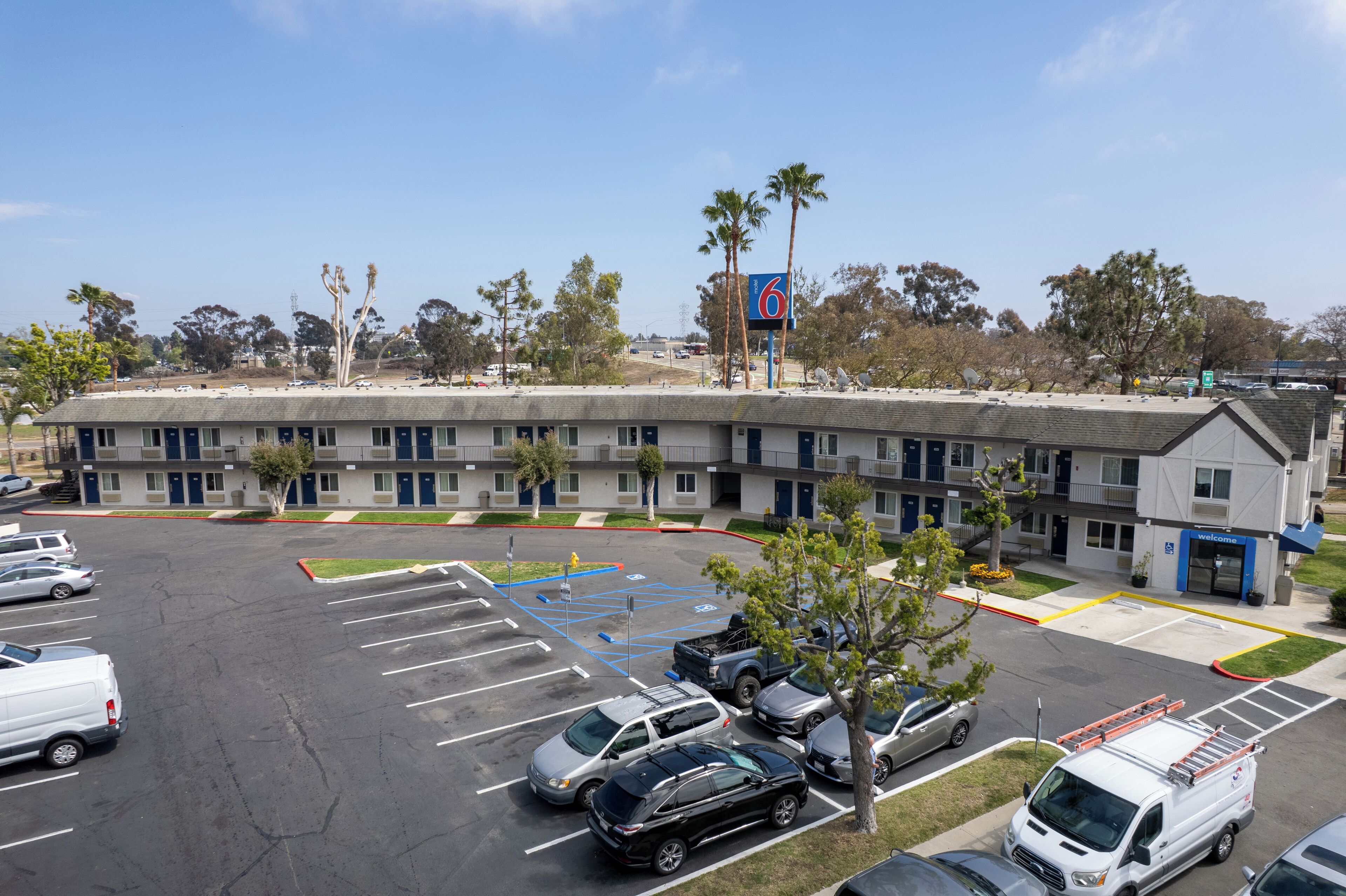 A motel with a parking lot, a fire truck, and a '6' sign indicating the building number.