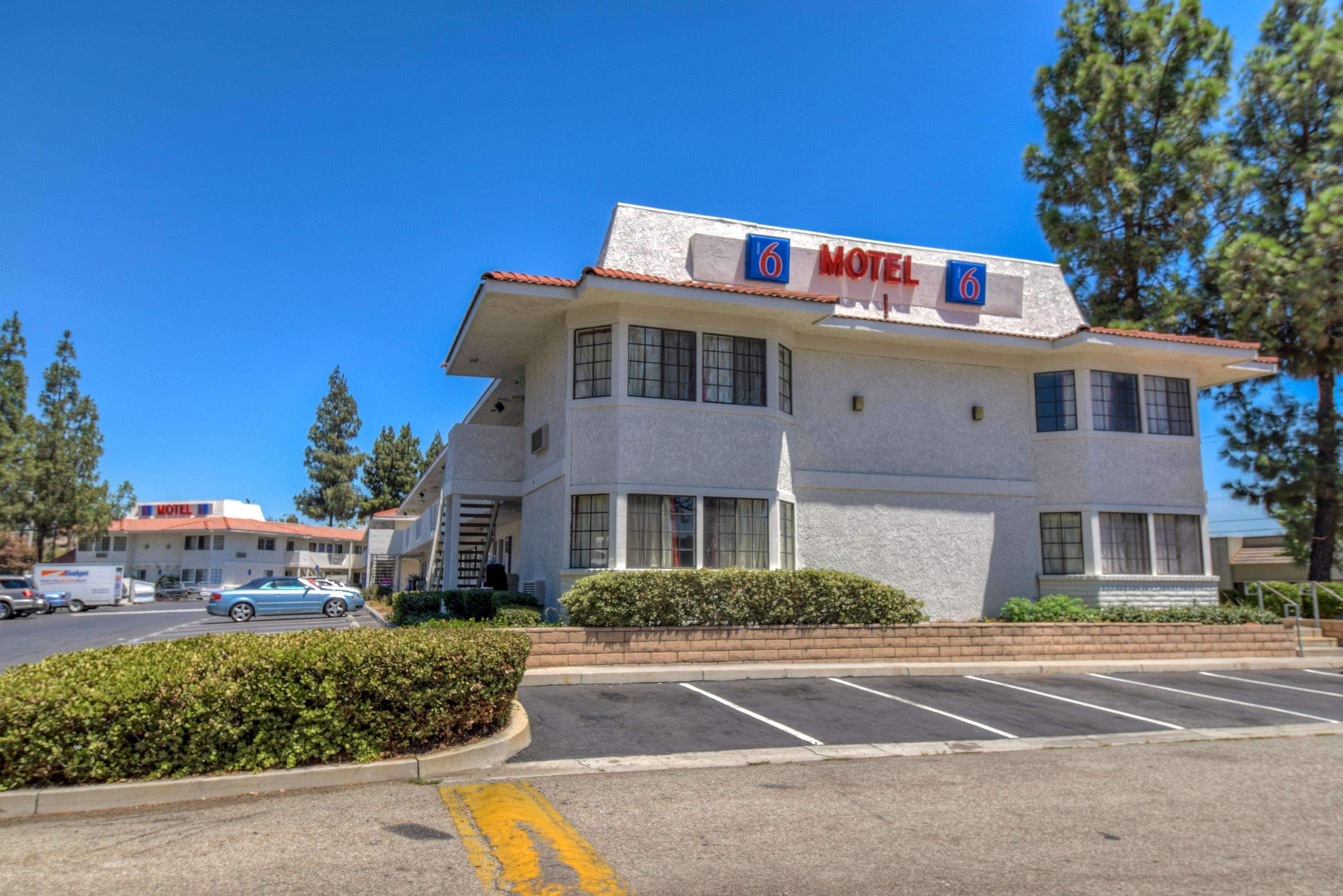 Un motel con techo rojo y un letrero que indica que es el número 6.