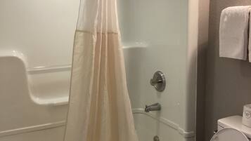 Un baño con bañera, ducha e inodoro.