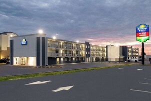Edificio de Days Inn & Suites con estacionamiento y flechas direccionales en el pavimento.