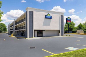 Edificio de Days Inn & Suites con estacionamiento, espacios de estacionamiento delimitados y un letrero que indica la cercanía de una licorería.