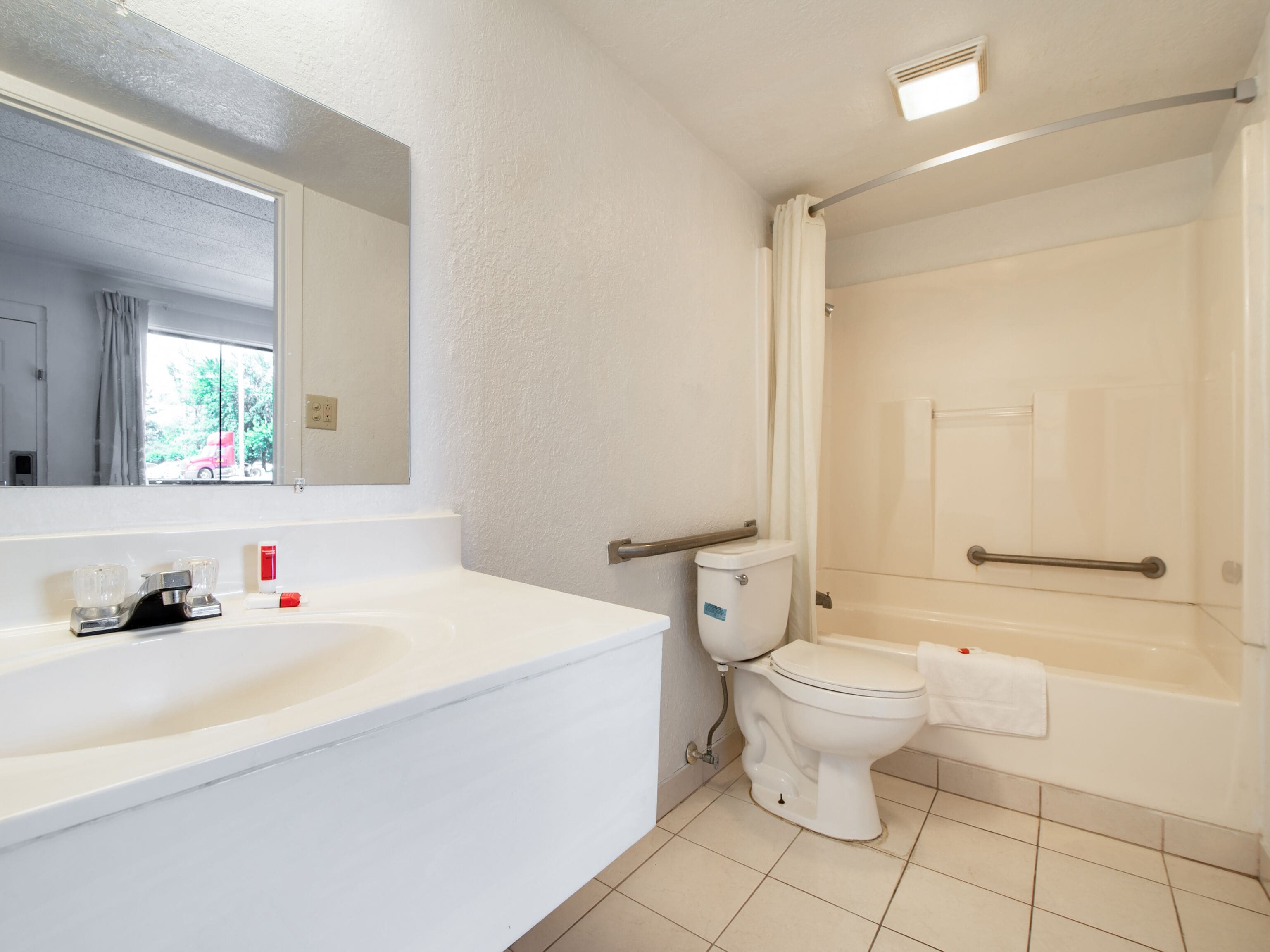 A bathroom with a white sink, toilet, and bathtub.