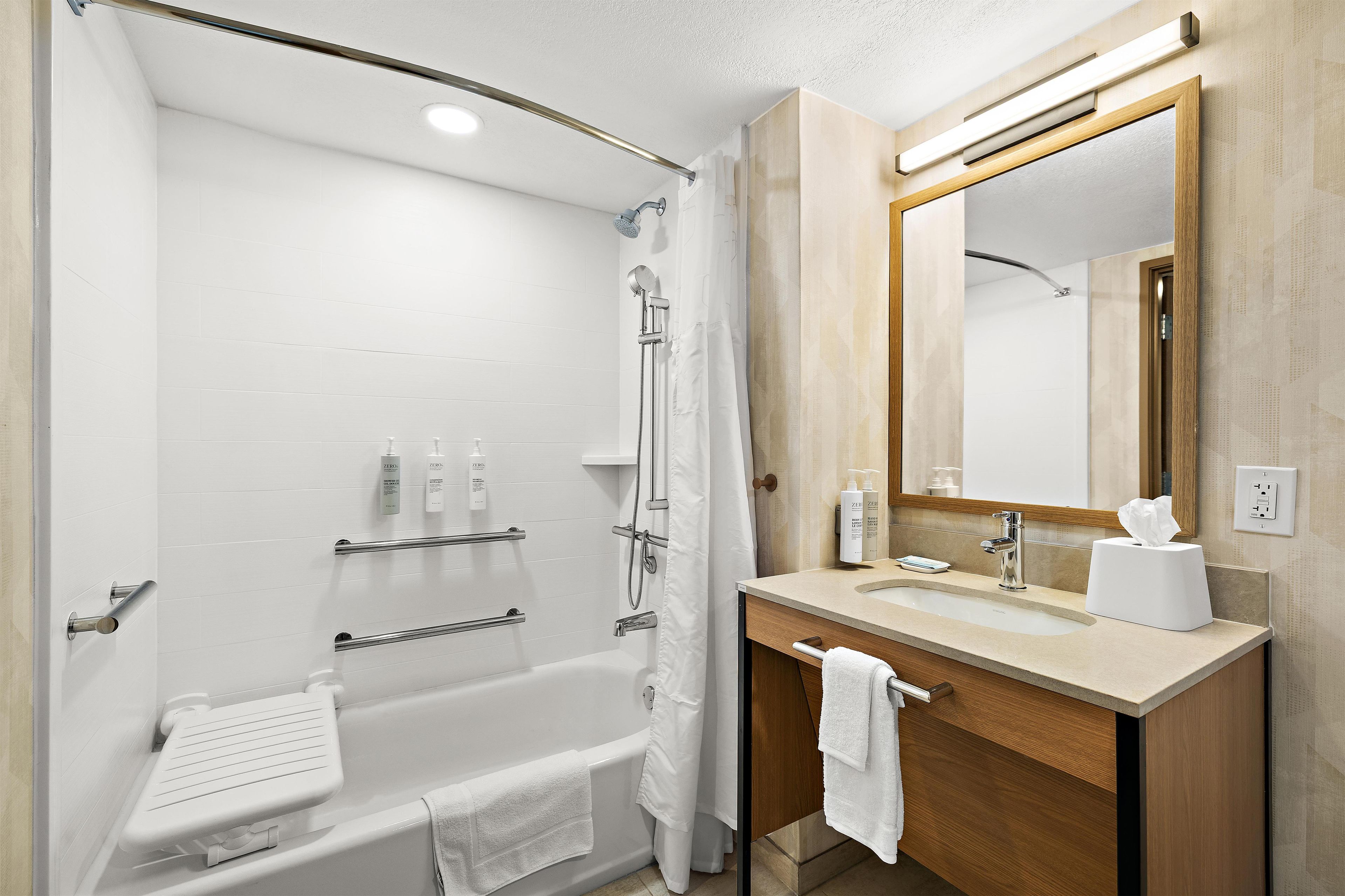 Een moderne badkamer met een inloopdouche, een badkuip, een wastafelmeubel en een spiegel.