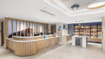 Een hotel receptie met een houten balie, een minibar en een snackbar.