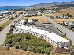A large building with multiple parking spaces and a road leading to the ocean. - Hampton Inn San Simeon Cambria (San Simeon)