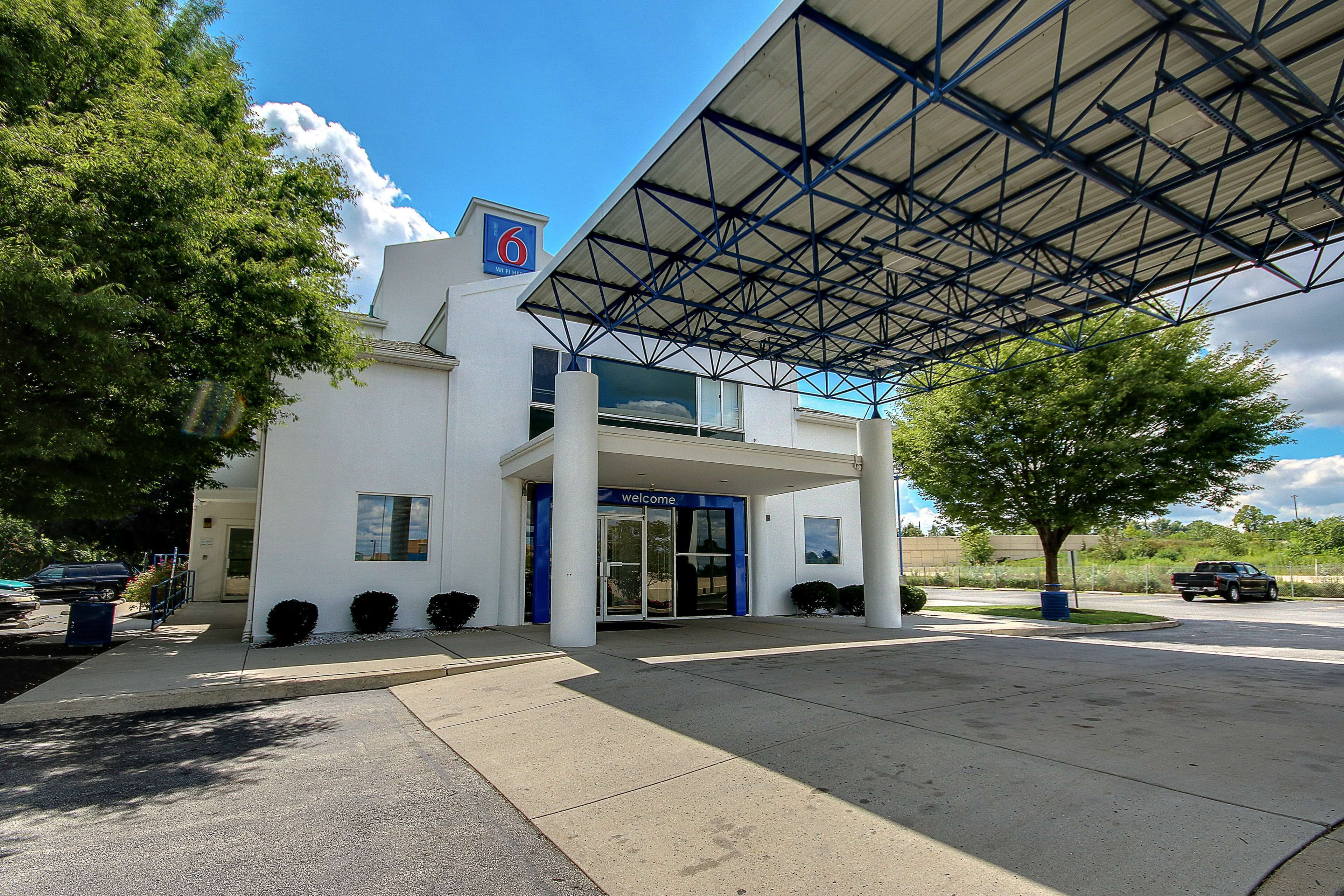 A modern building with a blue entrance and a covered parking area.