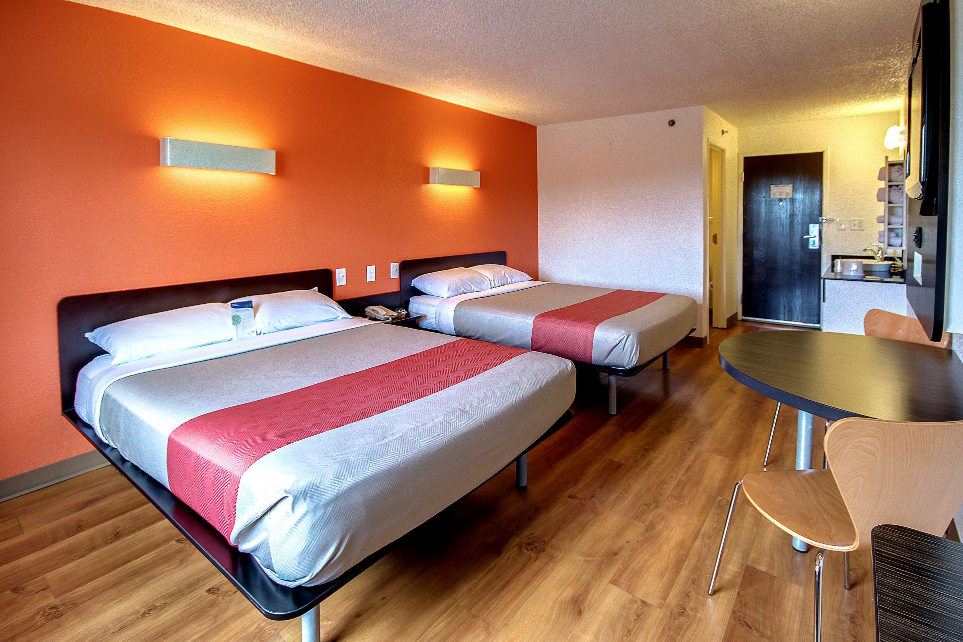 Une chambre d’hôtel avec deux lits, une petite table et une chaise.
