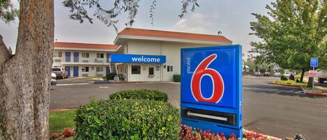 A motel sign with a '6' logo and a 'welcome' sign above it.