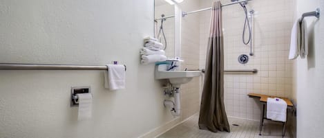 Une petite salle de bain propre, équipée de toilettes, d’un lavabo et d’une douche.
