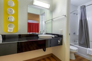Tina con regadera, toallas, papel de baño 