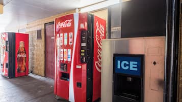 Una fila de máquinas expendedoras, incluyendo Coca-Cola e Ice-O-Matic, en un entorno comercial.