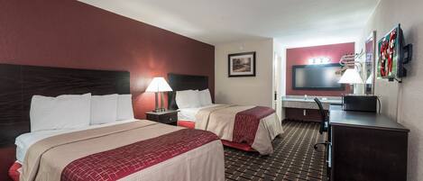 Une chambre d’hôtel avec deux lits, un bureau, une télévision et une salle de bain.