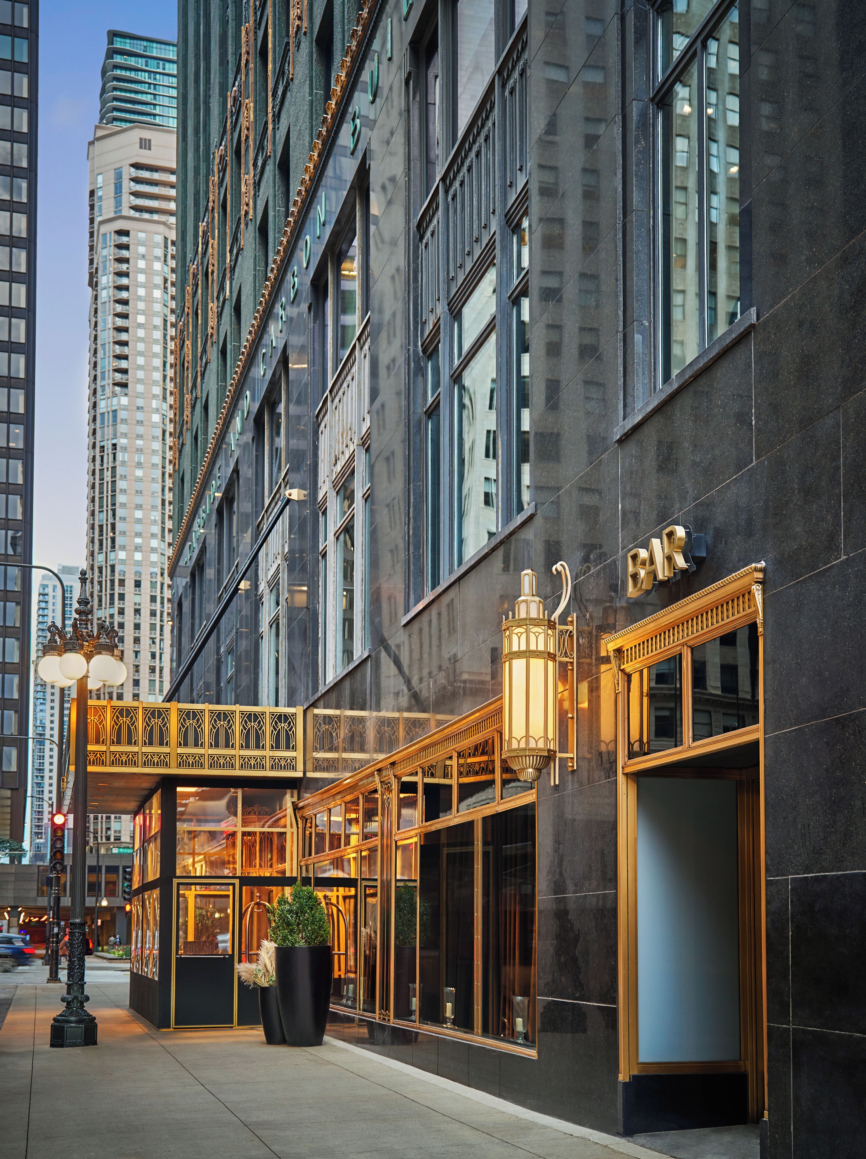 A modern building with a bar on the ground floor, large windows, and a decorative walkway.