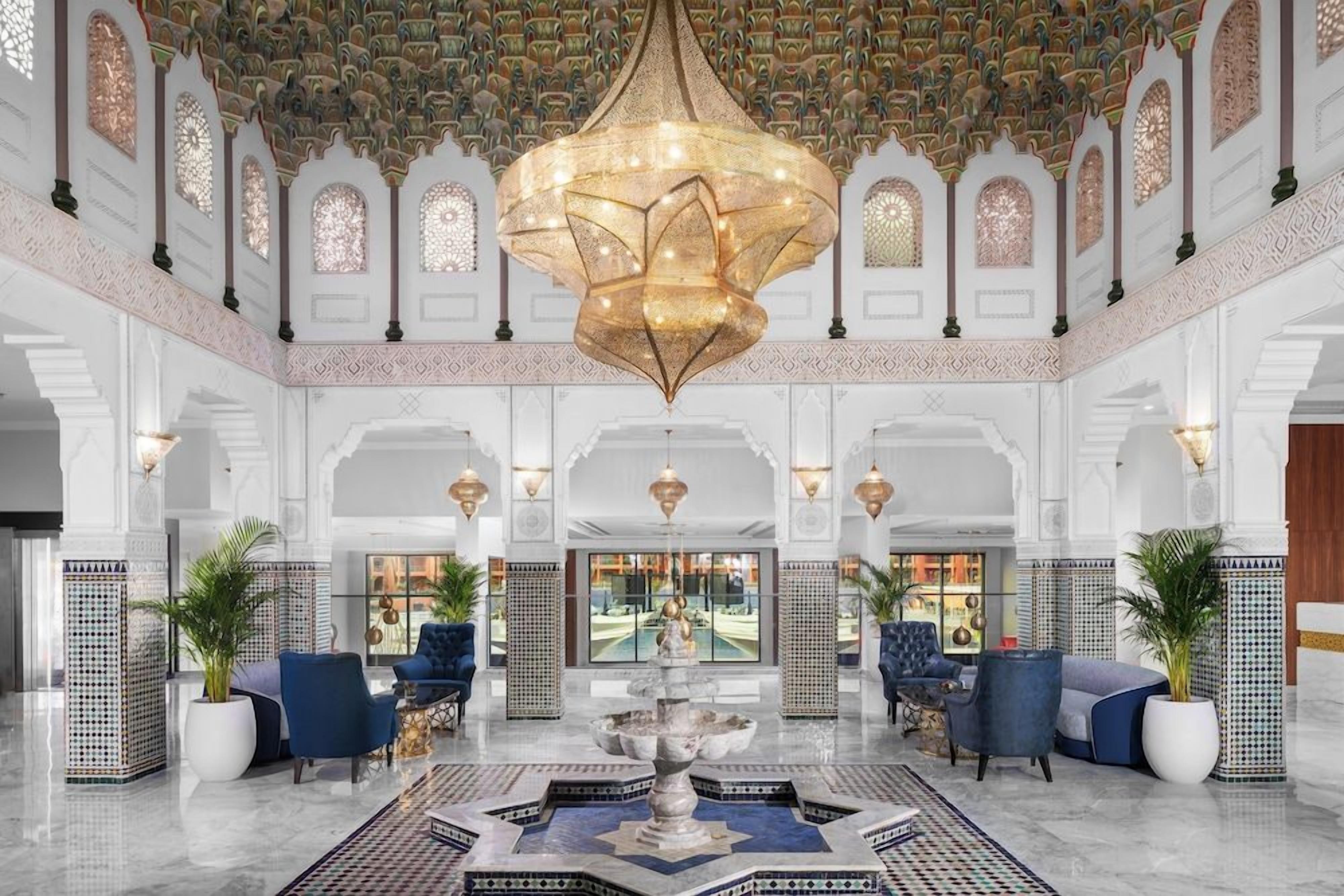 Eine Lobby mit einer zentralen Fontäne, Sitzbereichen und einem Chandelier.