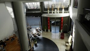 Un espacio interior amplio con diversas opciones de asientos, un columnario decorativo central y ventanas grandes que dejan entrar luz natural.