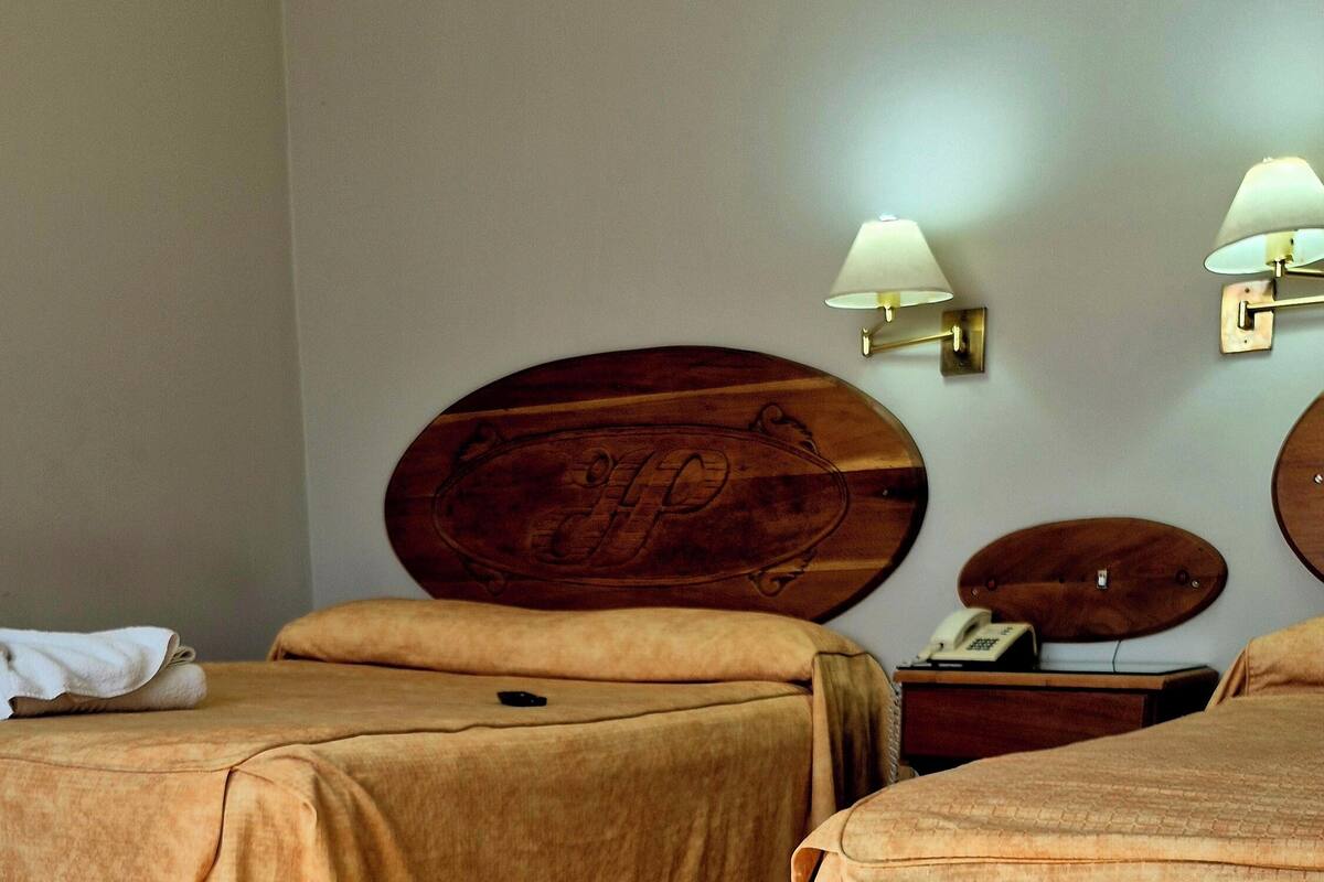 Ein Hotelzimmer mit zwei Betten, einem Holztisch und einer Minibar.