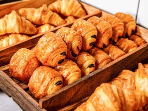 Een houten dienblad met warme, goudbruine croissants.