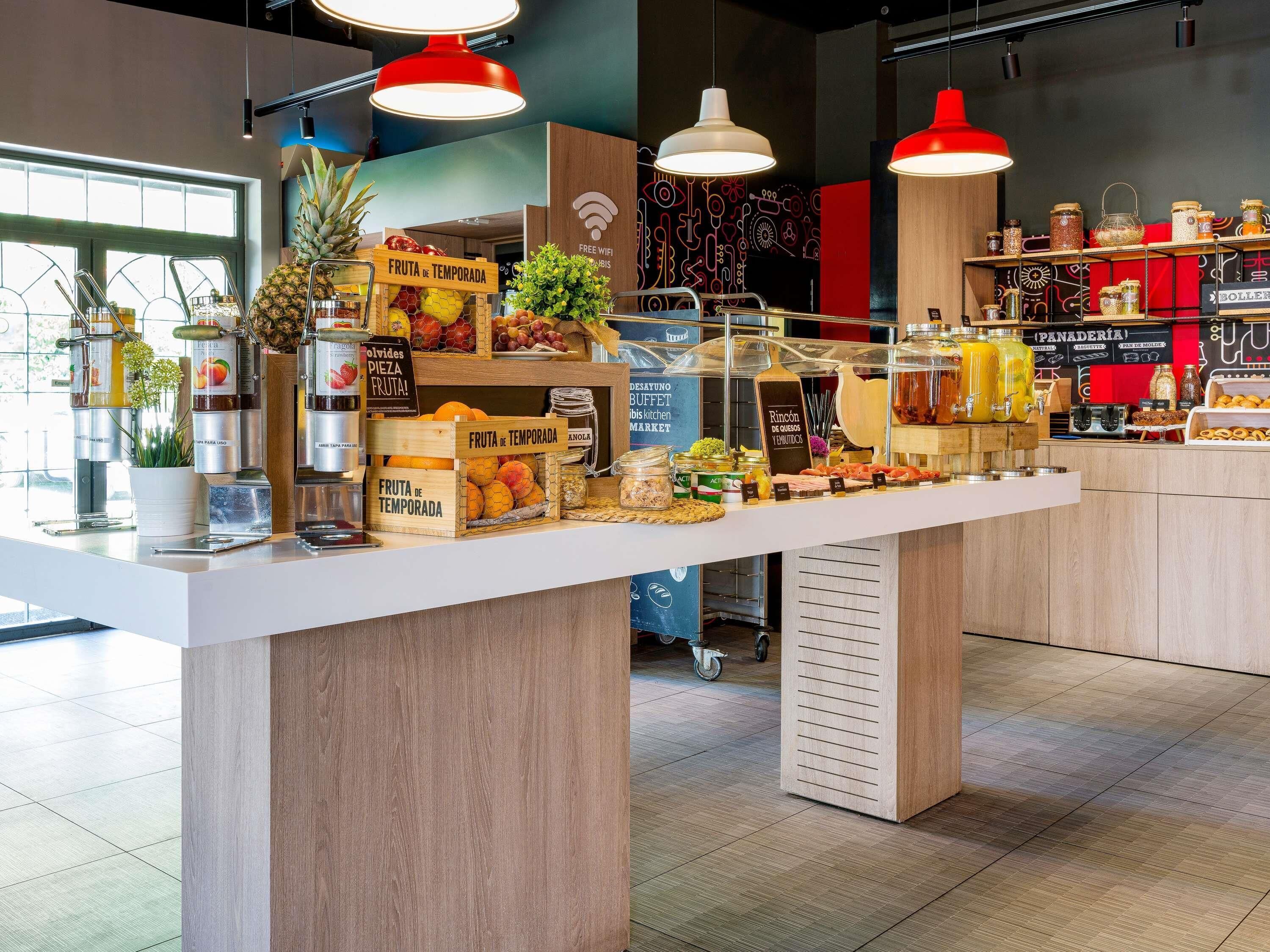 A breakfast bar with fruit, condiments, and a coffee station.