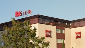 Un hotel de diseño moderno, con el logotipo de "ibis" bien visible en la fachada.