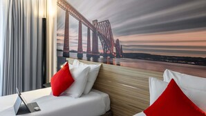 A hotel room with a bed, a bedside table with a lamp, and a large window with a view of a bridge. - Novotel Edinburgh Centre (Edinburgh)