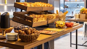 A breakfast buffet with various pastries, fruits, and a coffee machine. - Novotel Edinburgh Centre (Edinburgh)
