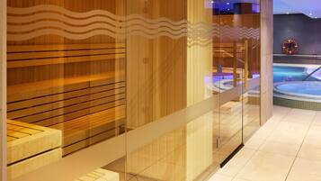 Een modern wellnessruimte met houten lambrisering en glazen deuren, een zichtbare hottub en een reddingsboei aan de muur.
