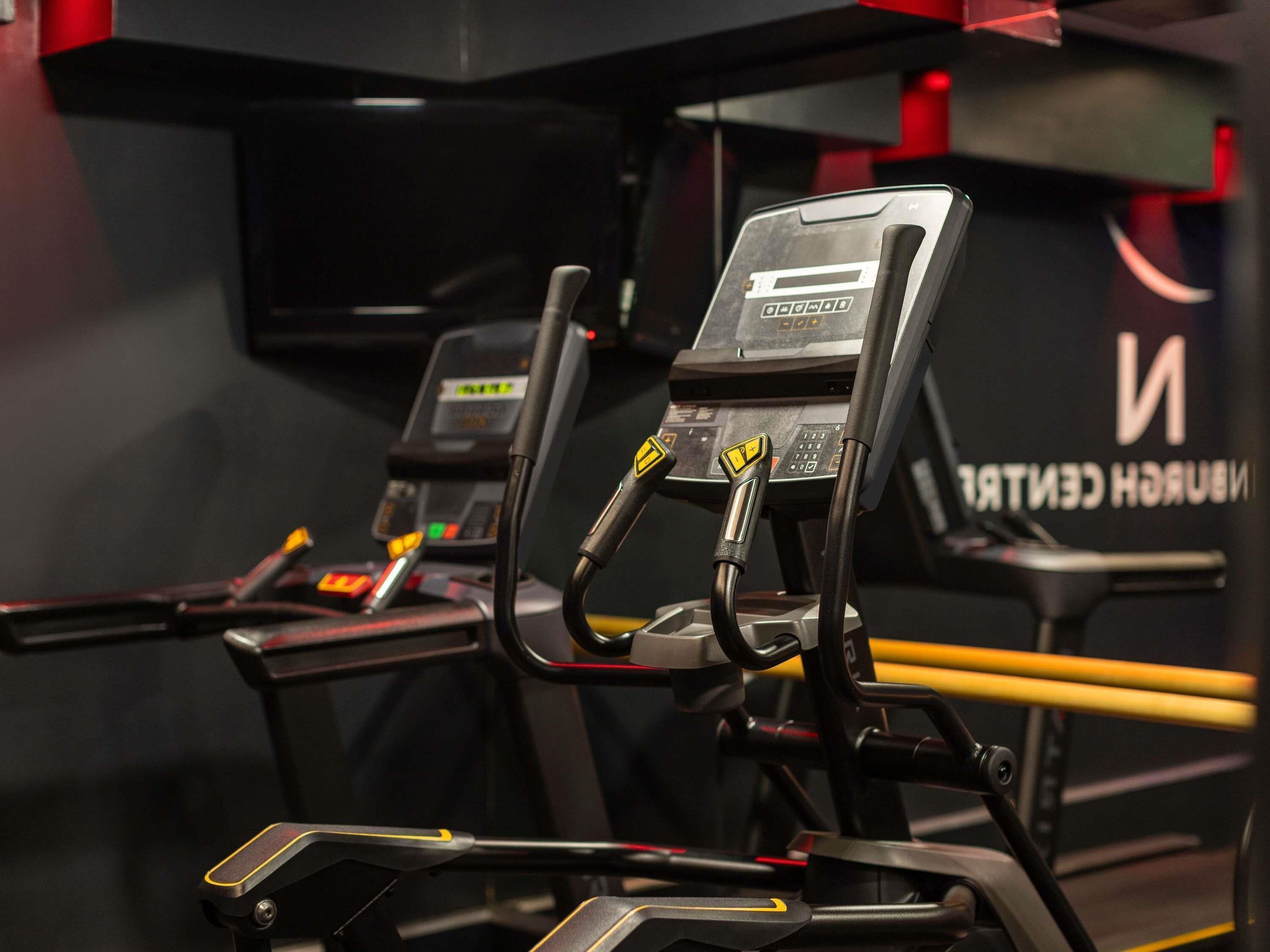 Une salle de sport équipée de vélos d’appartement et d’un panneau de commande.