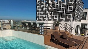 A rooftop pool with lounge chairs and a modern building in the background. - Rio Design Copacabana Hotel (Rio de Janeiro)