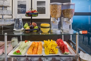 A buffet with various fruits, vegetables, and cereals.