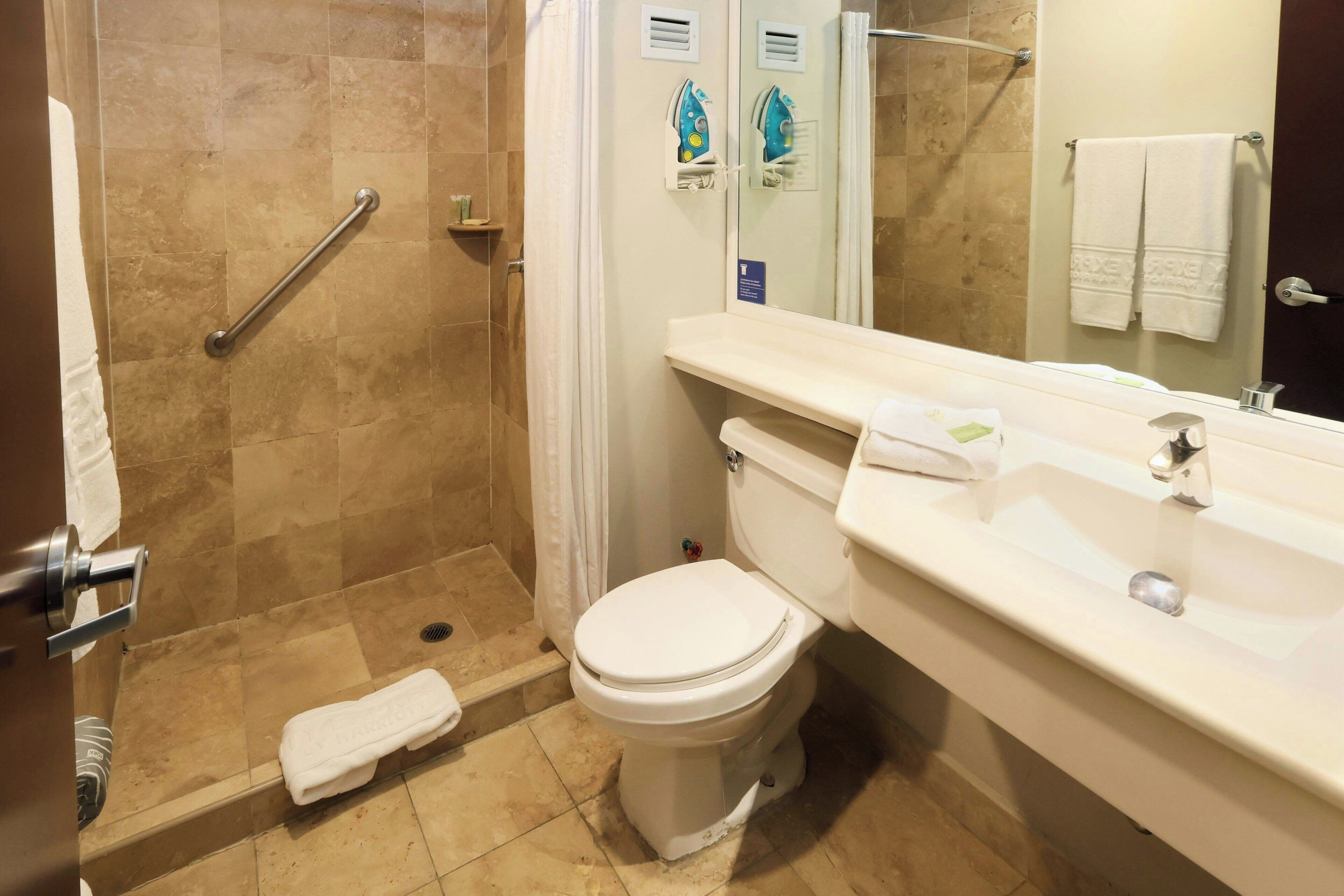 Ein Badezimmer mit Dusche, Toilette und Waschbecken.