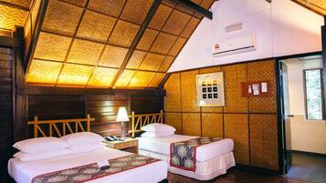 Une chambre avec deux lits, un plafond en bois, un appareil de climatisation, une table de chevet avec une lampe et un tableau électrique fixé au mur.