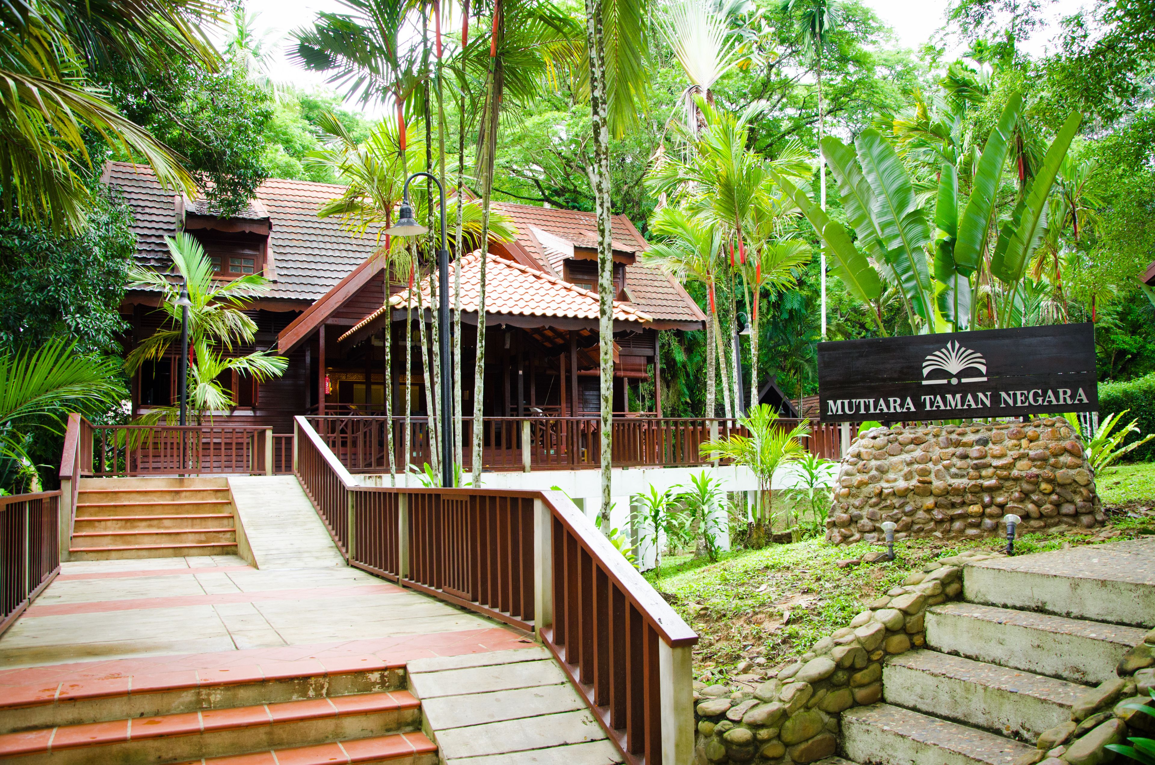 A wooden building with a sign reading "Mutiara Taman Negara".