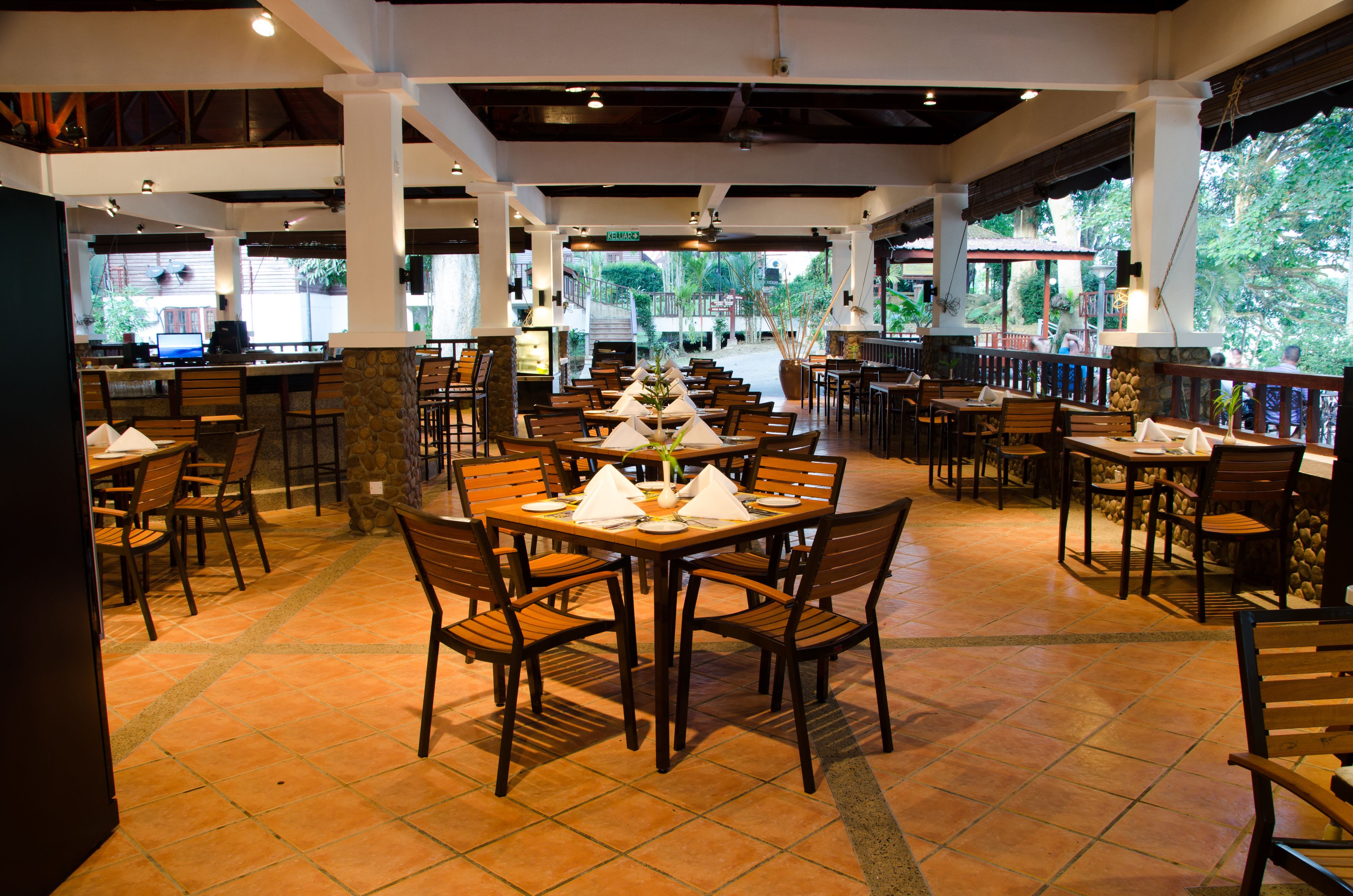 A restaurant with multiple dining tables and chairs, a tiled floor, and a view of the outdoors.