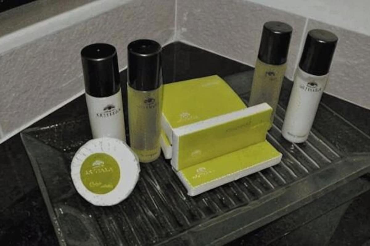 A bathroom counter with toiletries including a bottle, a box, and a container.