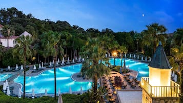 Una piscina techada, sombrillas, sillones reclinables de piscina