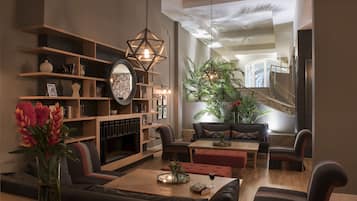 Una sala de estar moderna con chimenea, asientos cómodos y una planta grande.