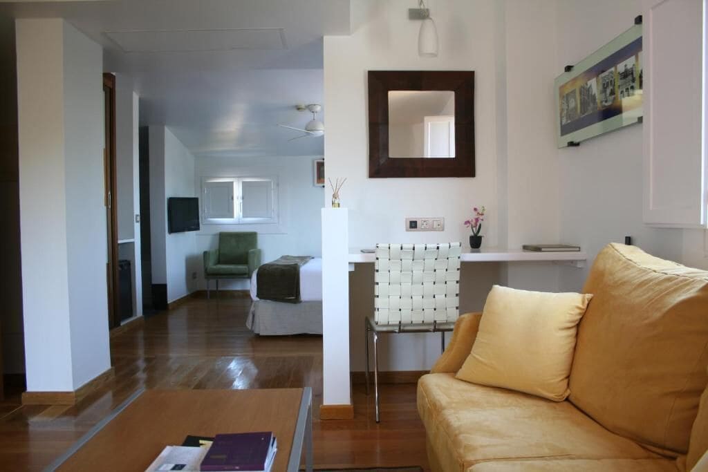 A living room with a sofa, a chair, a coffee table, and a TV.