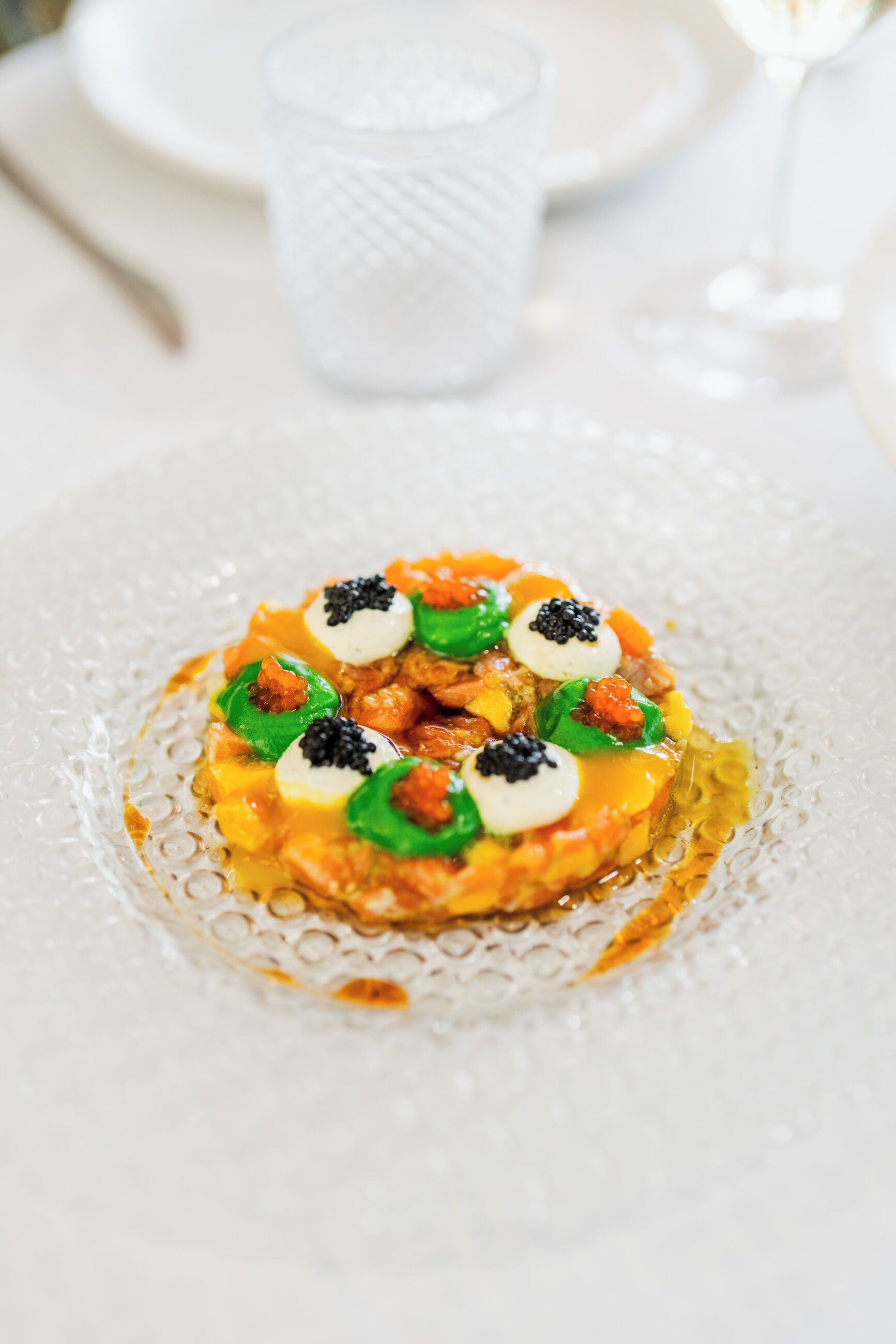 Et nærbillede af en gourmetret på en hvid tallerken med en struktureret kant.